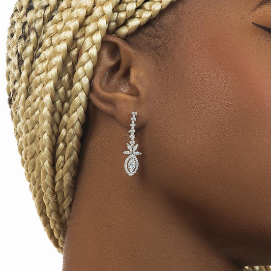 Close-up of a diamond earring on an ear with braided hair.