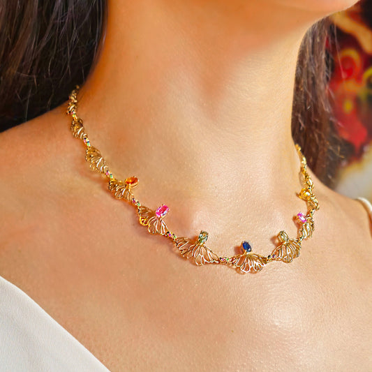 Gold necklace with colorful beads on a person's neck