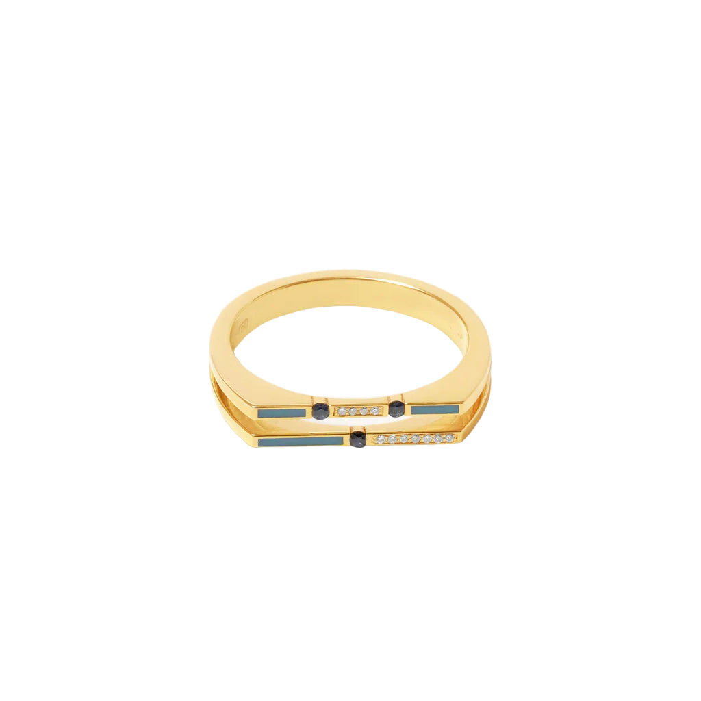 Gold ring with embedded stones on a light beige background