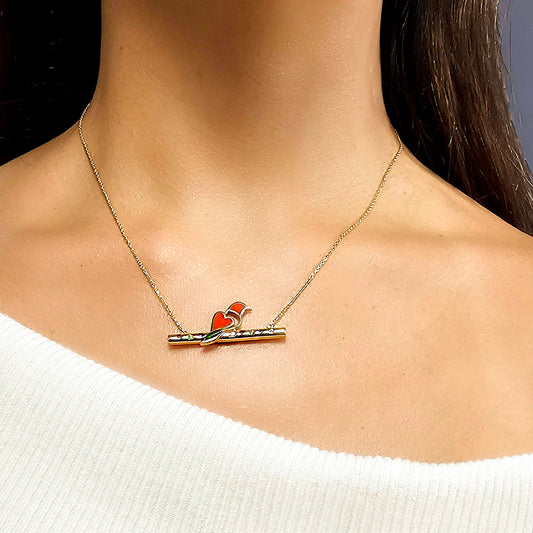 Necklace with a red and orange pendant on a person wearing a white sweater.