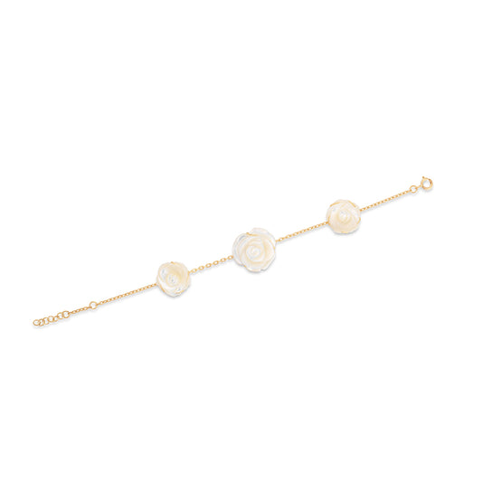 Gold bracelet with three pearl-like beads on a white background