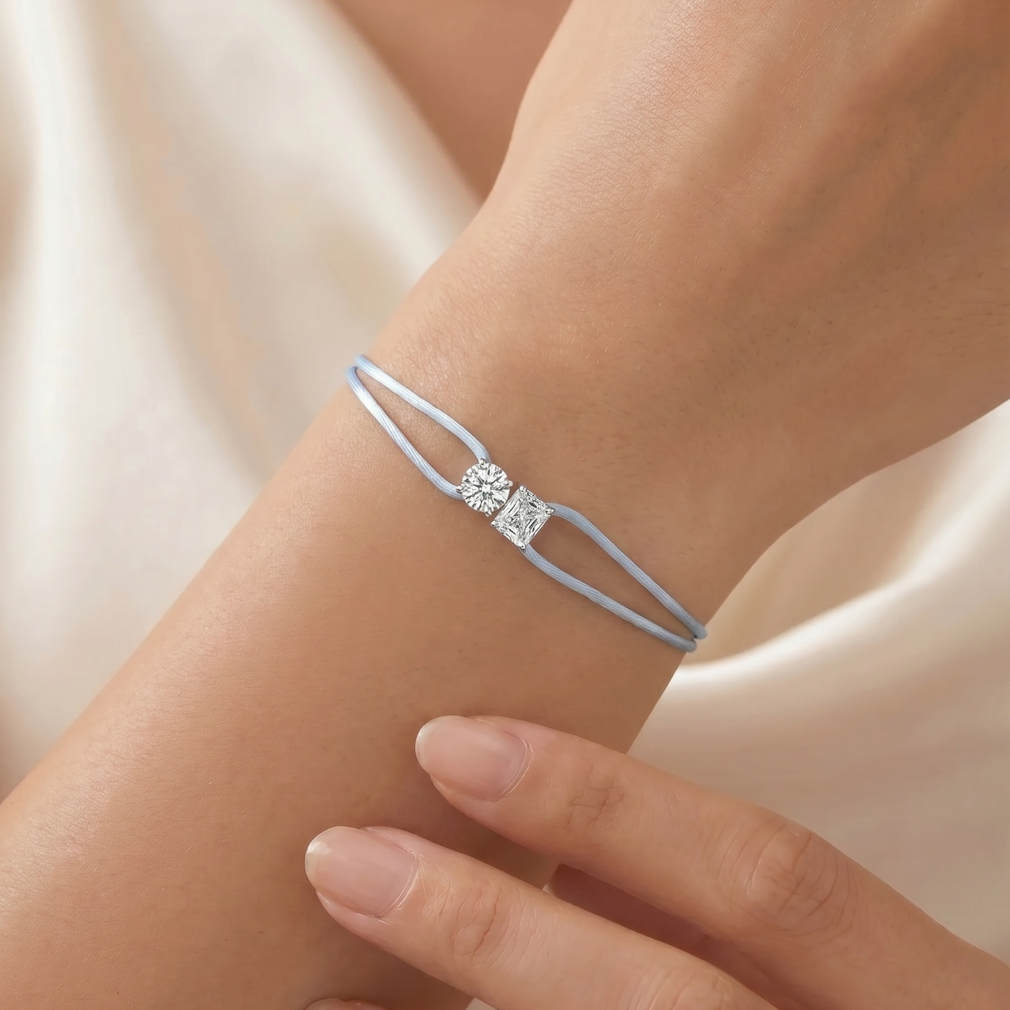 Blue bracelet with a diamond on a wrist against a neutral background
