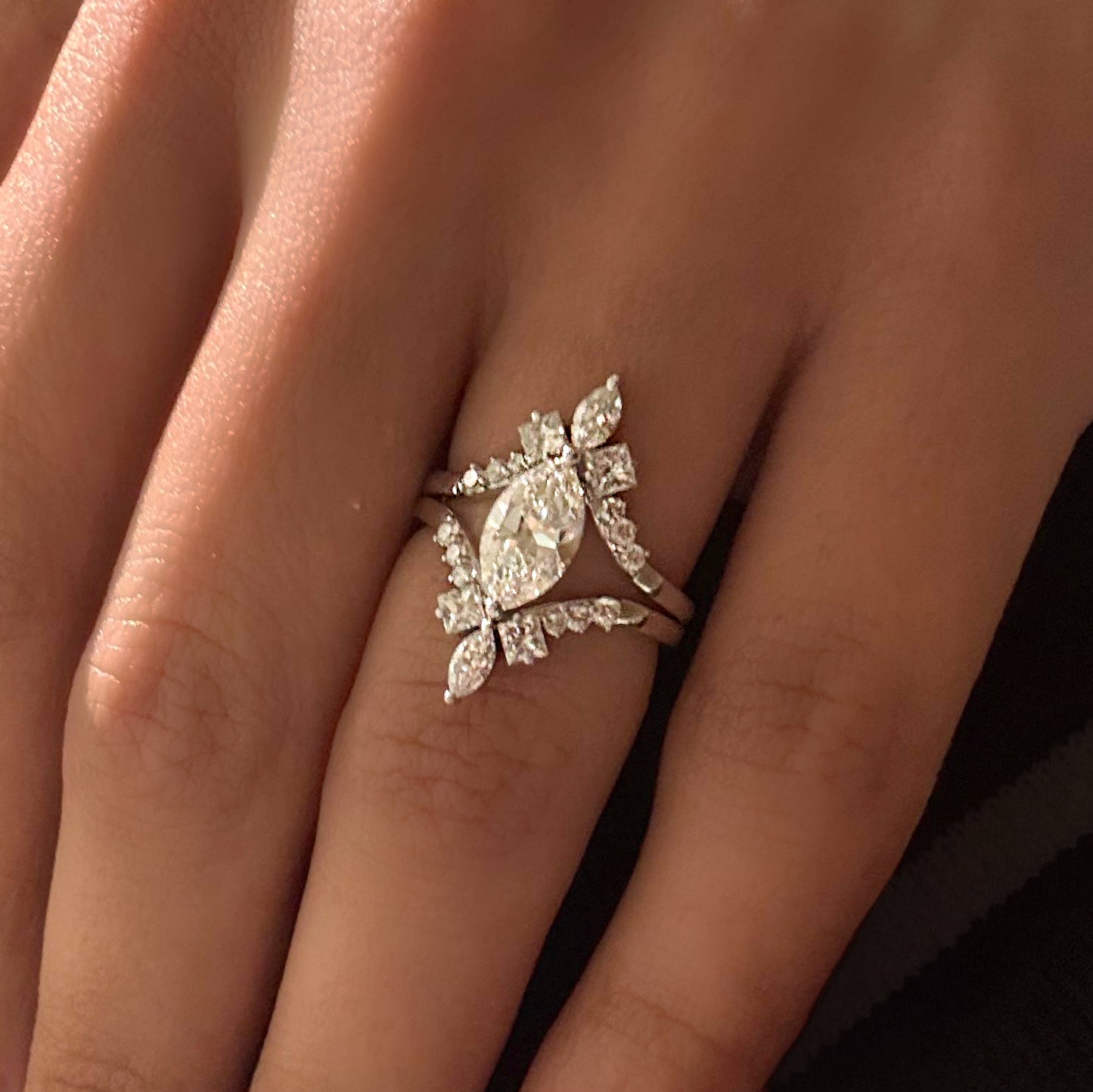 White gold ring with a diamond design on a person's finger