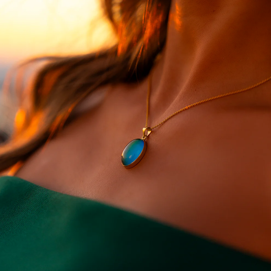 Necklace with a blue pendant worn by a person, with a blurred background