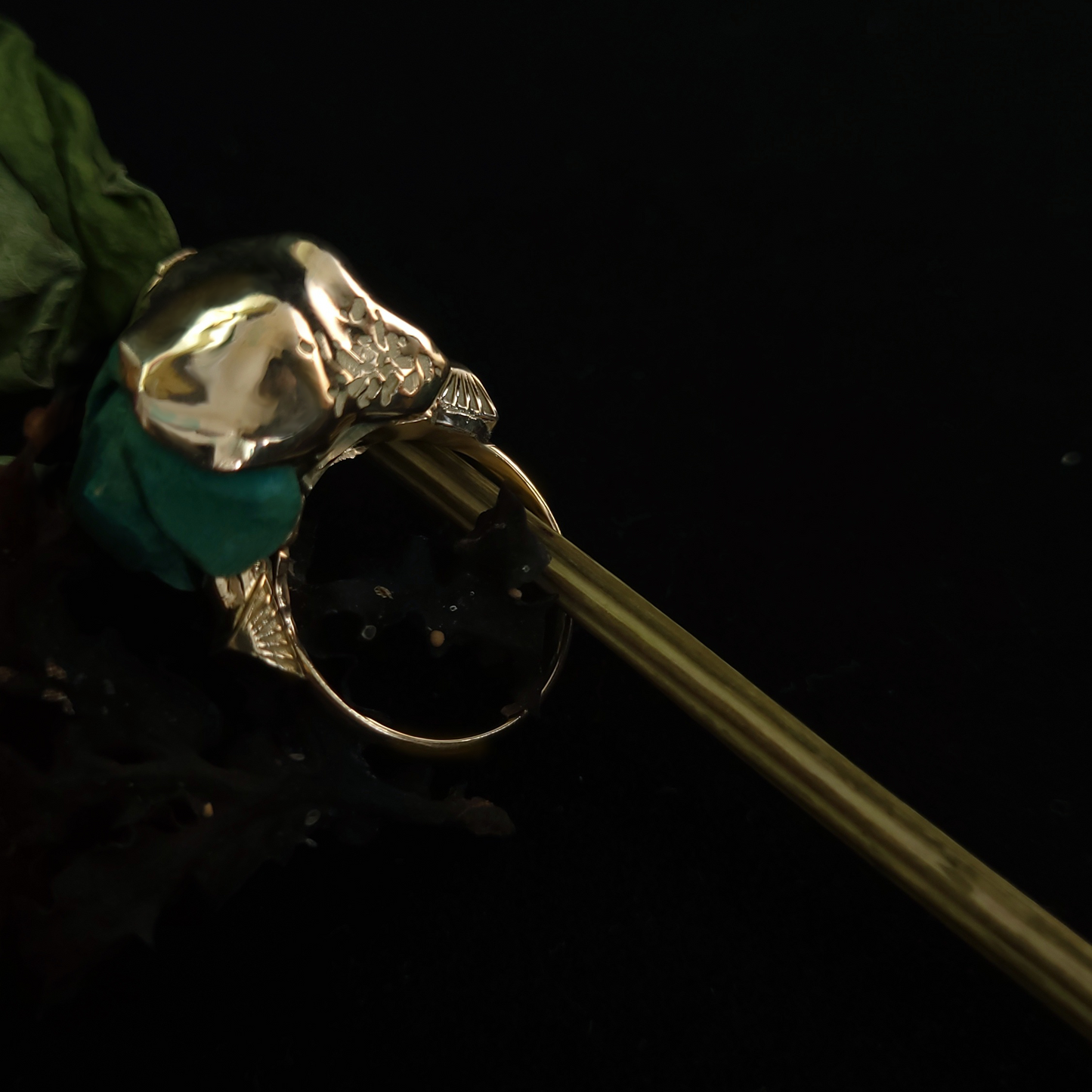 Gold ring with a green gemstone on a black background
