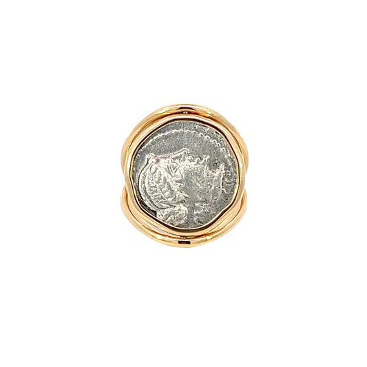 Gold ring with a silver coin embedded in the center on a white background