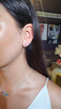 Caleums Love Earrings with ruby and diamond details worn on the ear