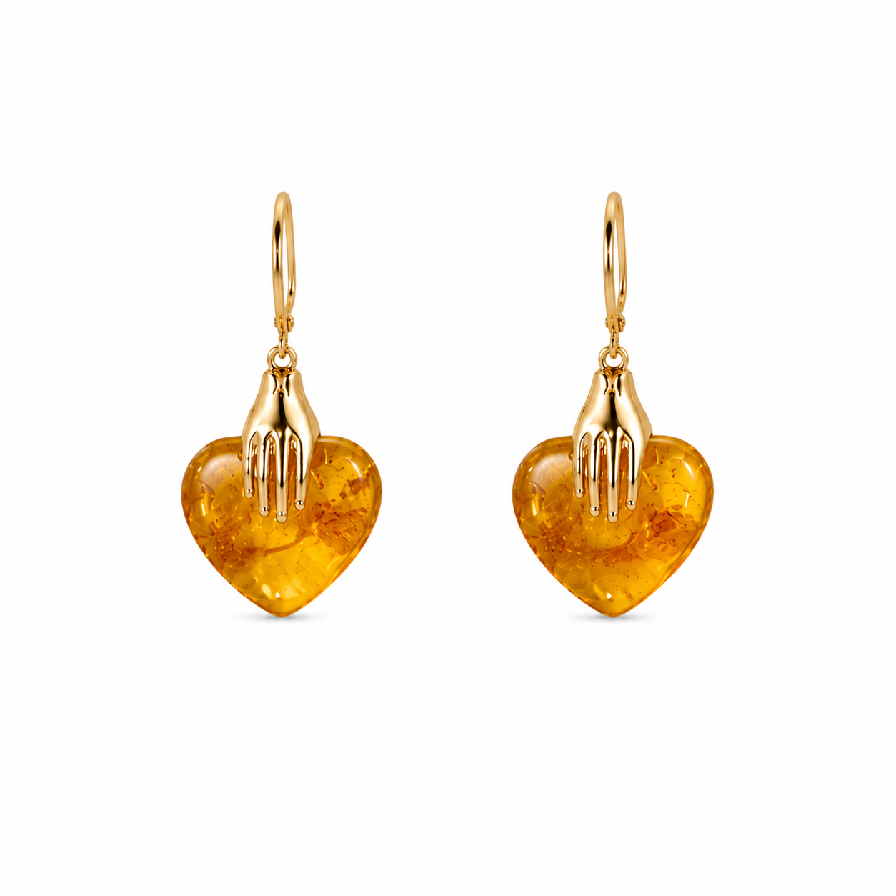 Heart-shaped amber earrings with gold hooks on a white background