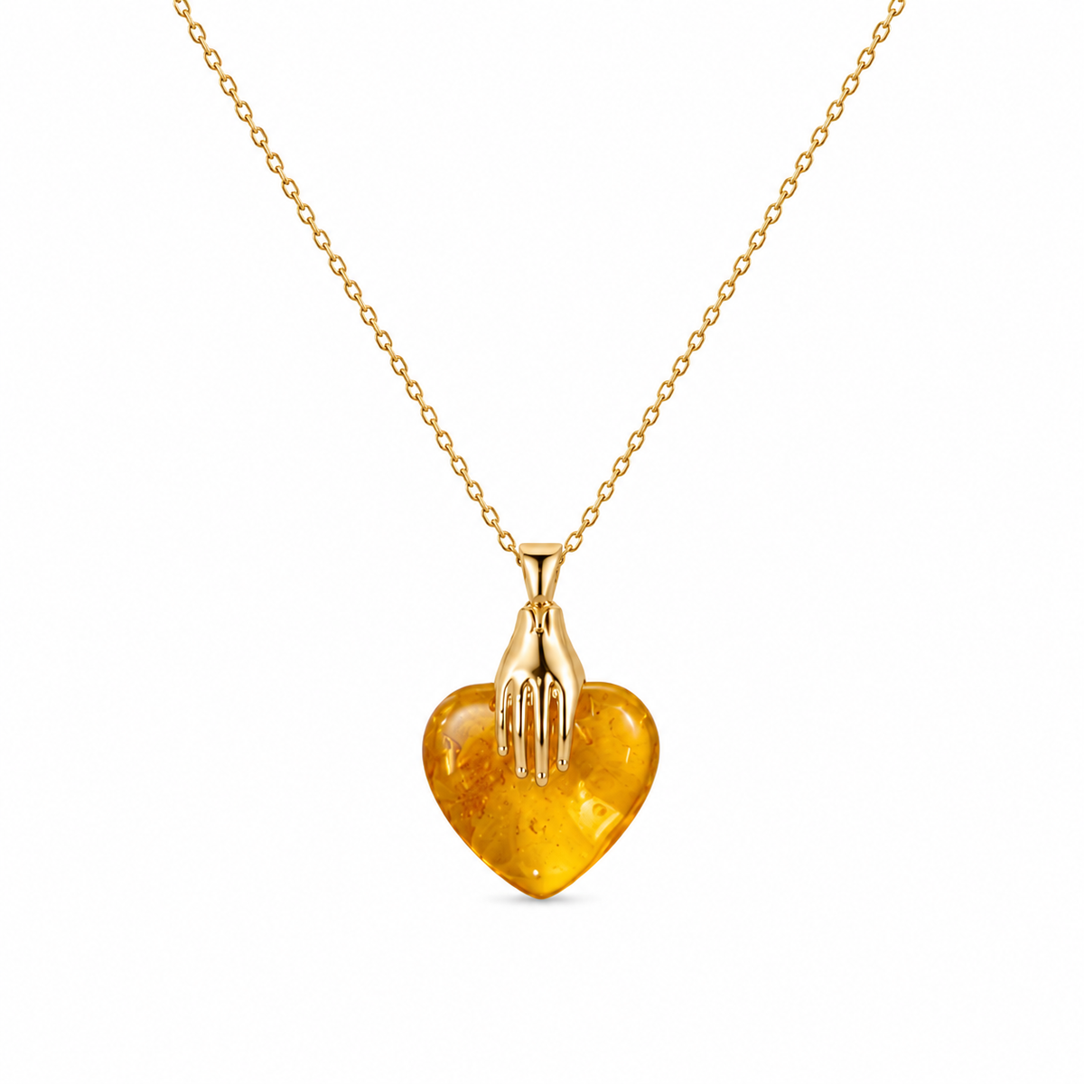 Gold necklace with a heart-shaped amber pendant on a white background