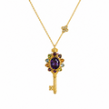 Gold necklace with a key-shaped pendant featuring purple gemstones on a white background