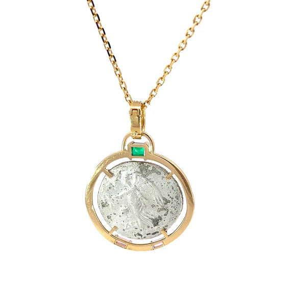 Gold necklace with a pendant featuring a green gemstone on a white background