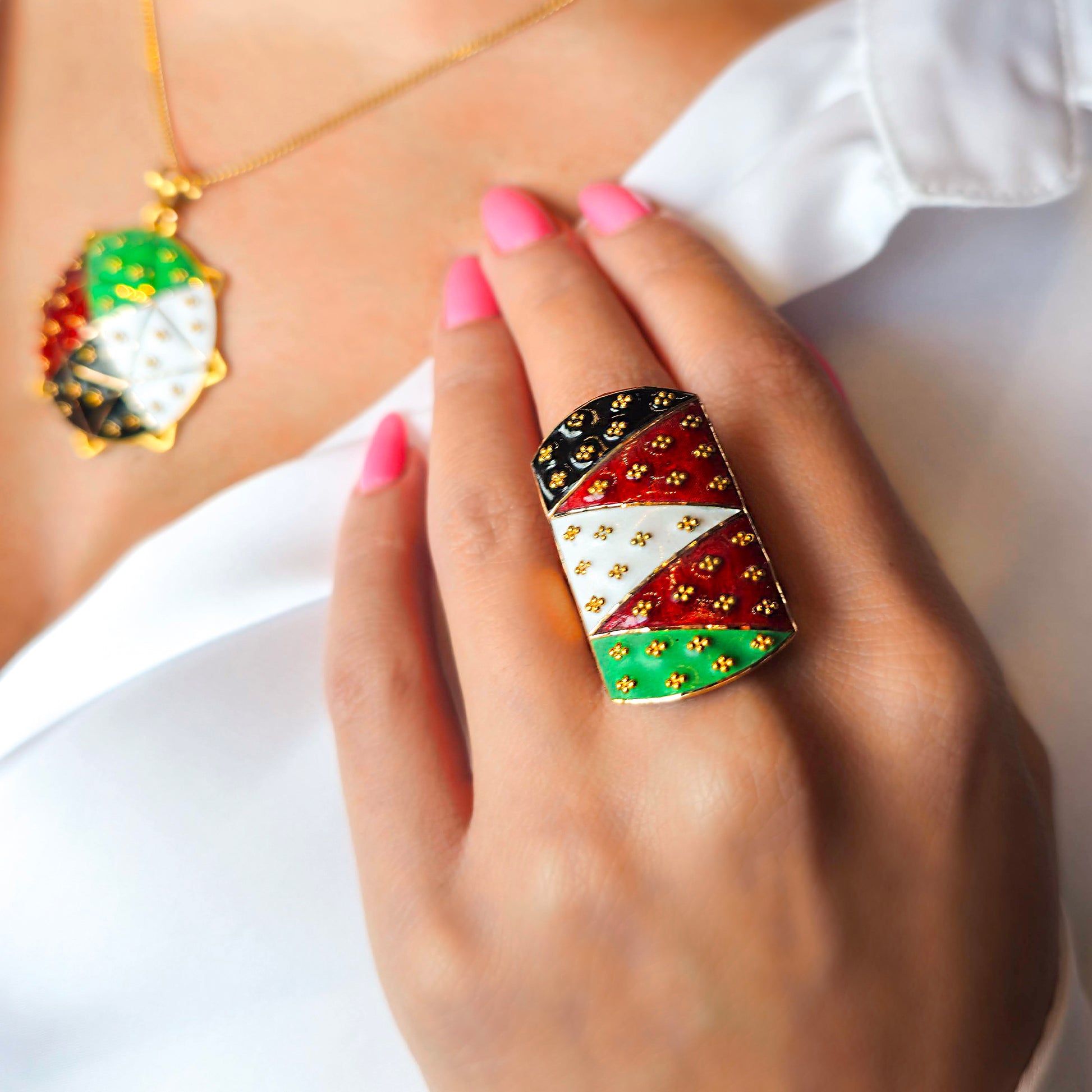 Close-up of a hand wearing a colorful ring with a blurred background