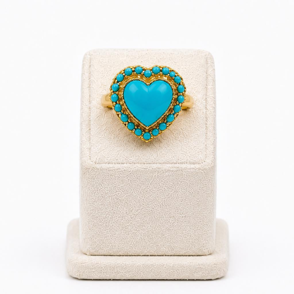 Turquoise heart-shaped ring on a white stand with a white background