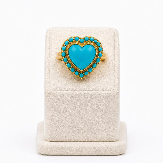 Turquoise heart-shaped ring on a white stand with a white background