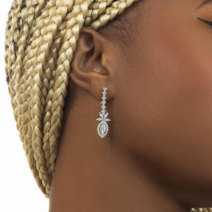 Close-up of a diamond earring on an ear with braided hair.
