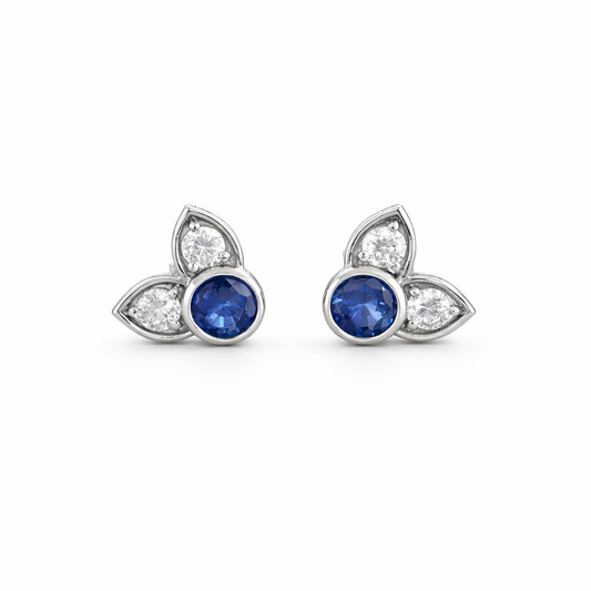 Pair of earrings with blue gemstones and diamond accents on a white background
