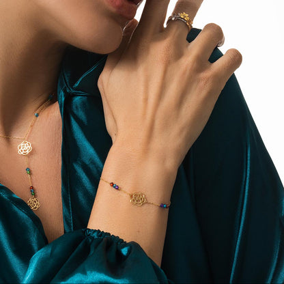 Close-up of a person wearing gold jewelry with a green satin garment.