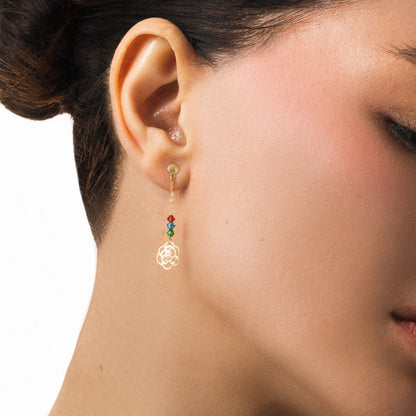 Close-up of an ear wearing a colorful earring with a neutral background