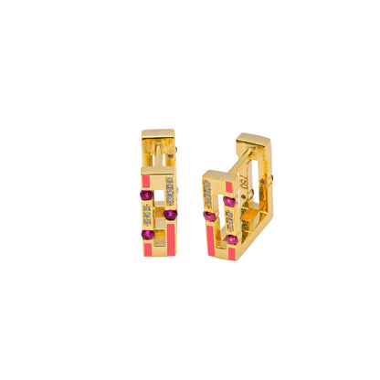 Gold earrings with red and clear gemstones on a white background