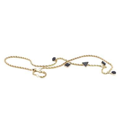 Gold chain necklace with black stones on a white background