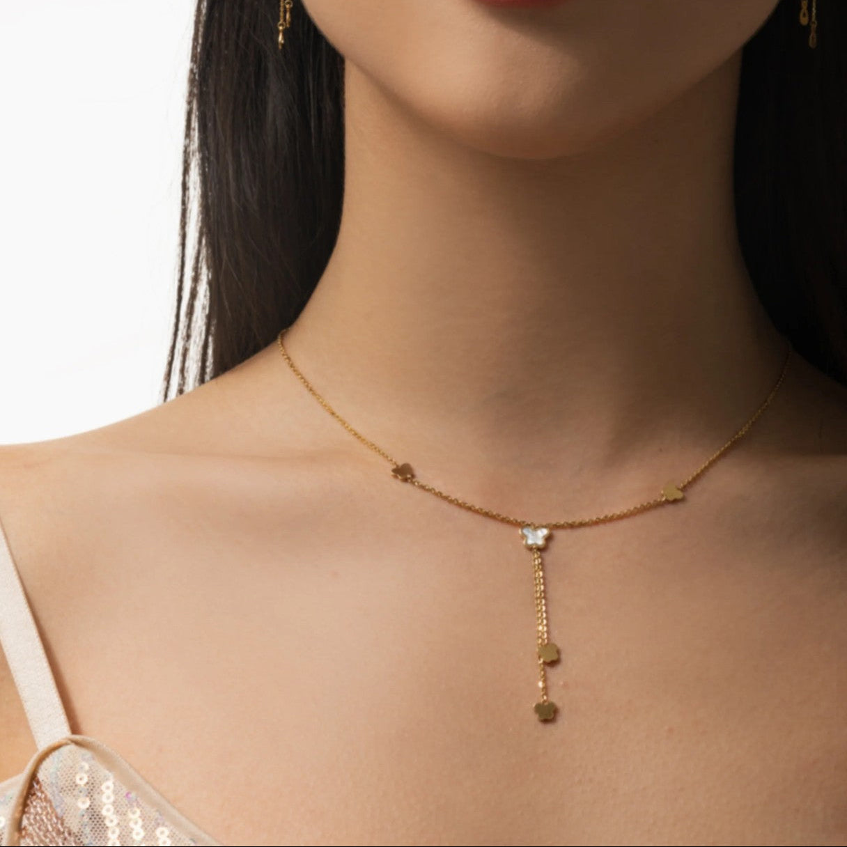 Gold necklace with a pendant on a model against a neutral background