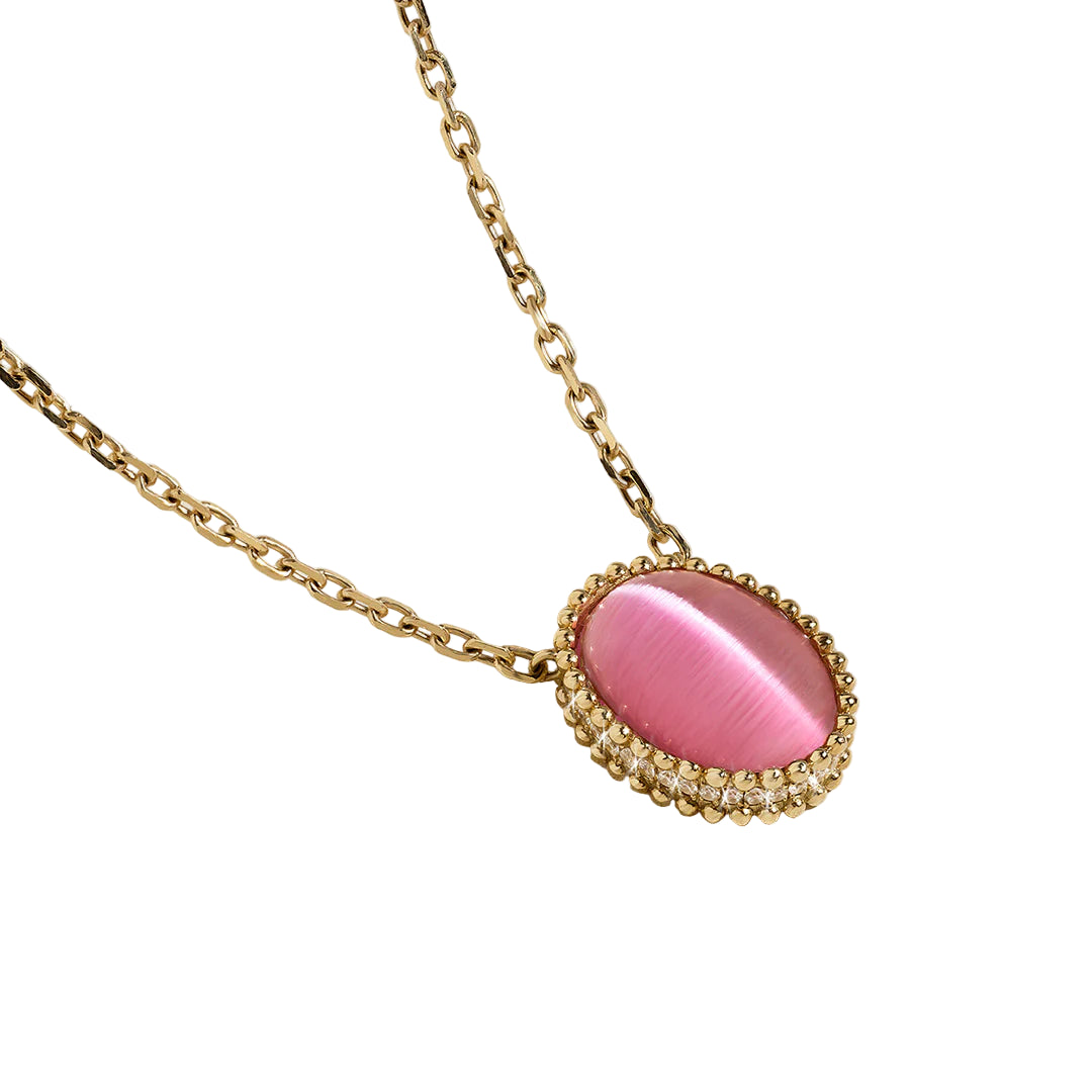 Gold necklace with a pink cat's eye gemstone pendant on a white background