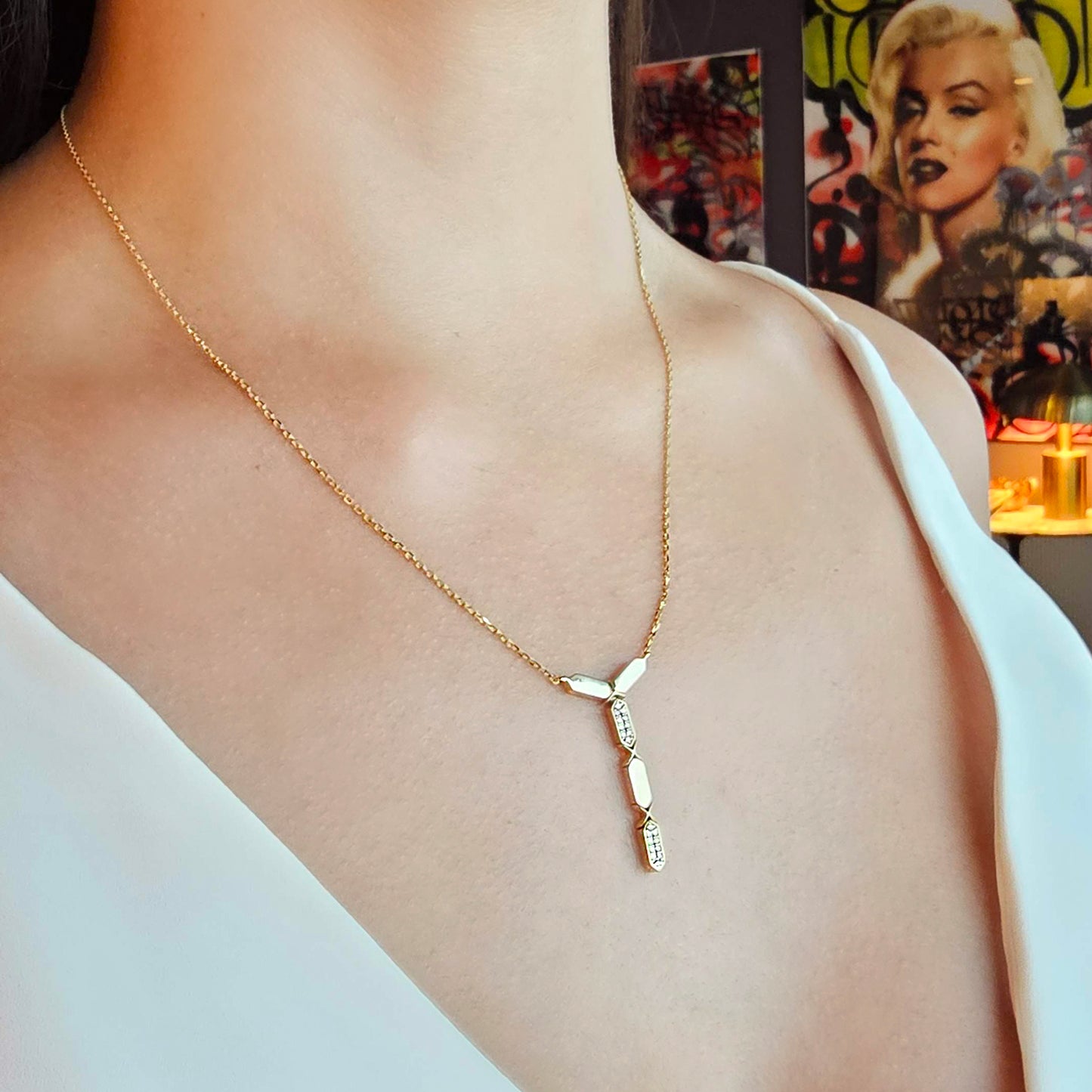 Gold necklace on a person with a colorful background