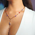 Necklace with colorful beads worn by a person against a neutral background