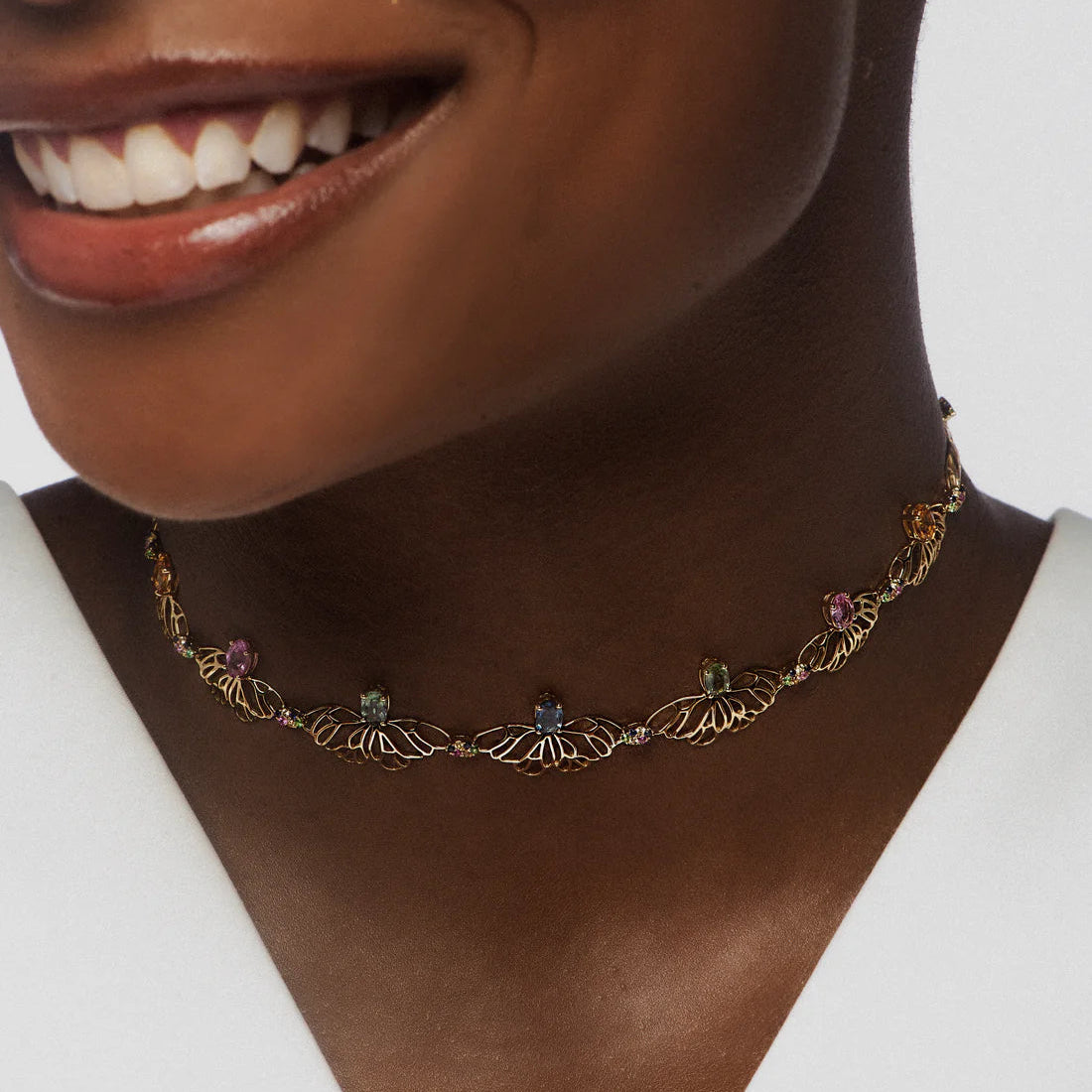 Necklace with gemstones worn by a person on a white background