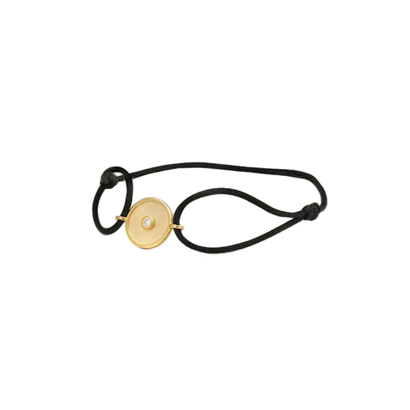 Black hair tie with a gold circular charm featuring a diamond on a white background
