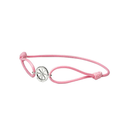 Pink bracelet with a white gold charm on a white background