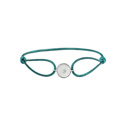 Teal bracelet with a white gold charm on a white background