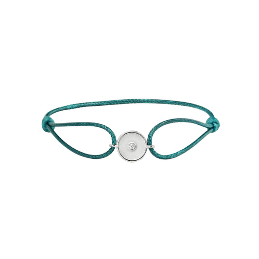 Teal bracelet with a white gold charm on a white background