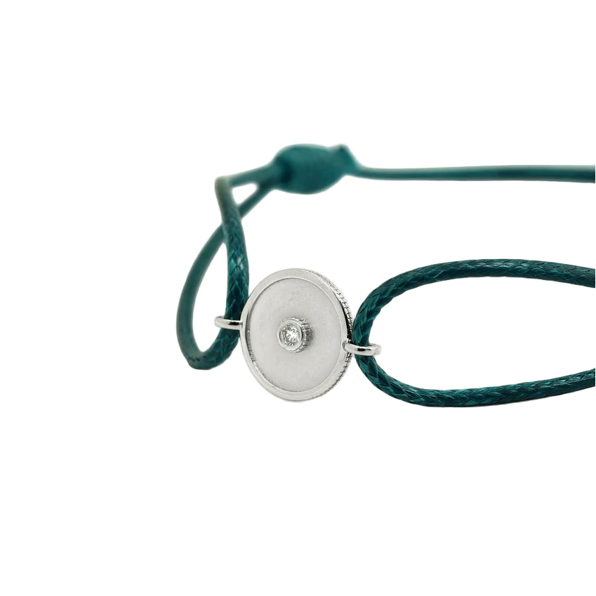 Green bracelet with a white gold clasp on a white background