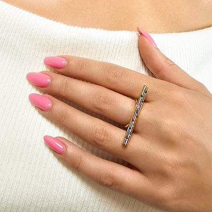 Hand with pink nails wearing a gold ring on a white background