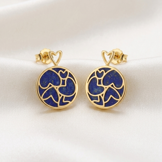 Gold earrings with blue heart designs on a white background