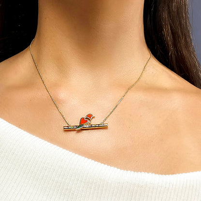 Necklace with a red and orange pendant on a person wearing a white sweater.