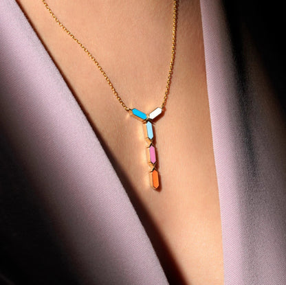 Necklace with colorful pendant on a person wearing a light purple garment