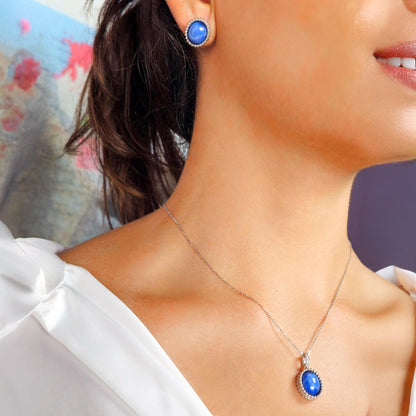 Close-up of a woman wearing a blue pendant necklace and matching earrings.