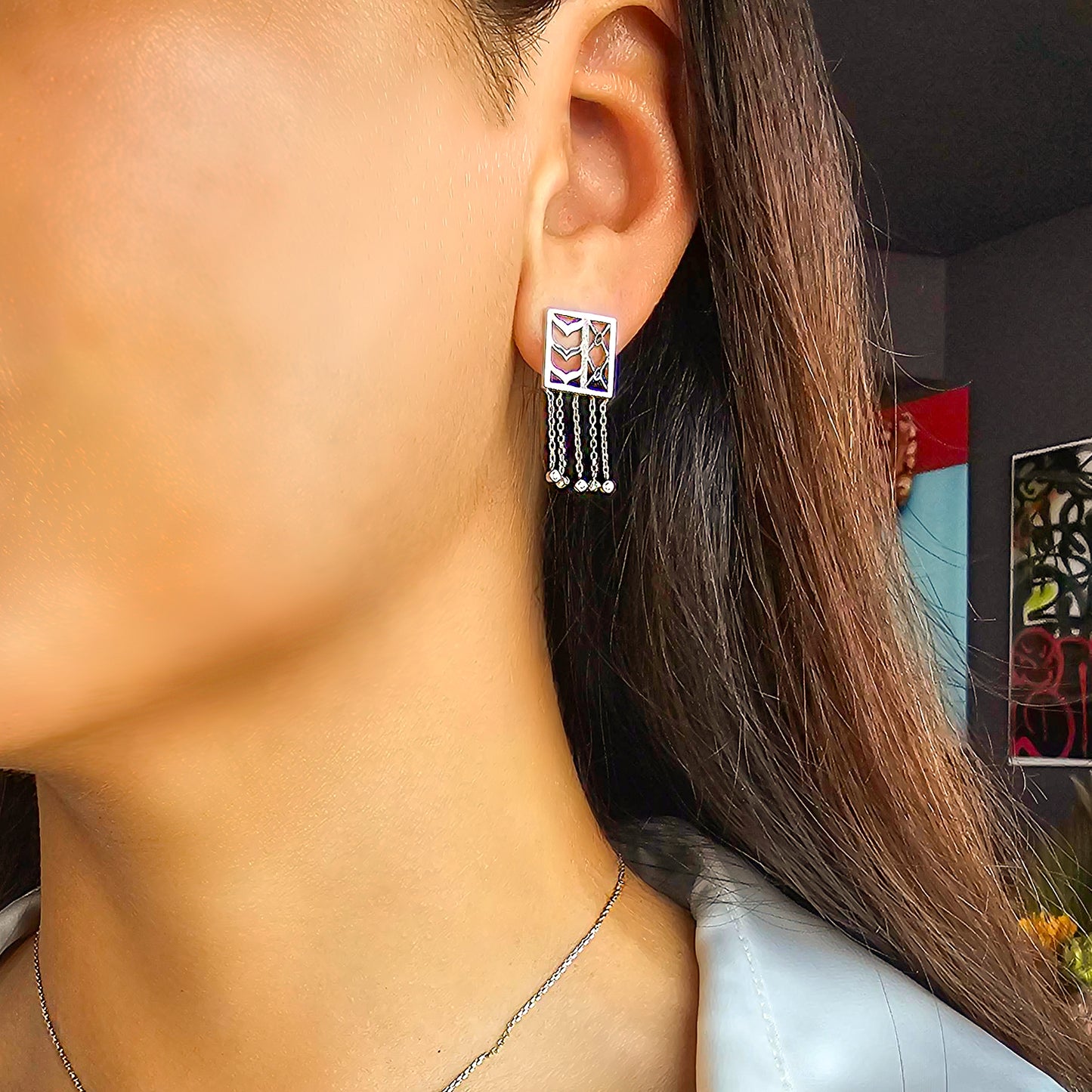 Close-up of a person wearing a white gold earring.