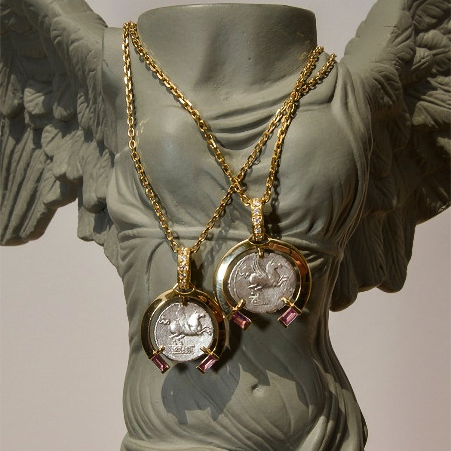 Gold necklaces with coin pendants on a classical statue