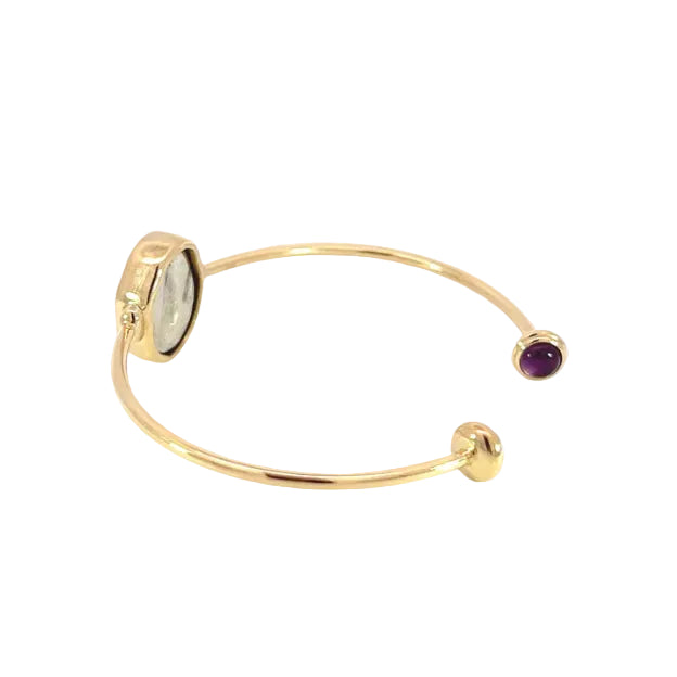 Gold bangle with gemstones on a white background