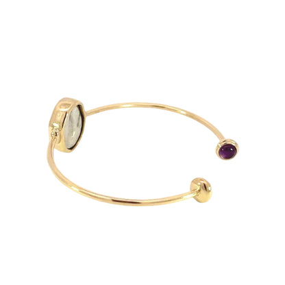Gold bangle with gemstones on a white background
