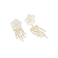 Pair of floral earrings with gold and pearl details on a white background