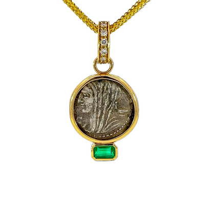 Gold pendant with a green gemstone on a white background
