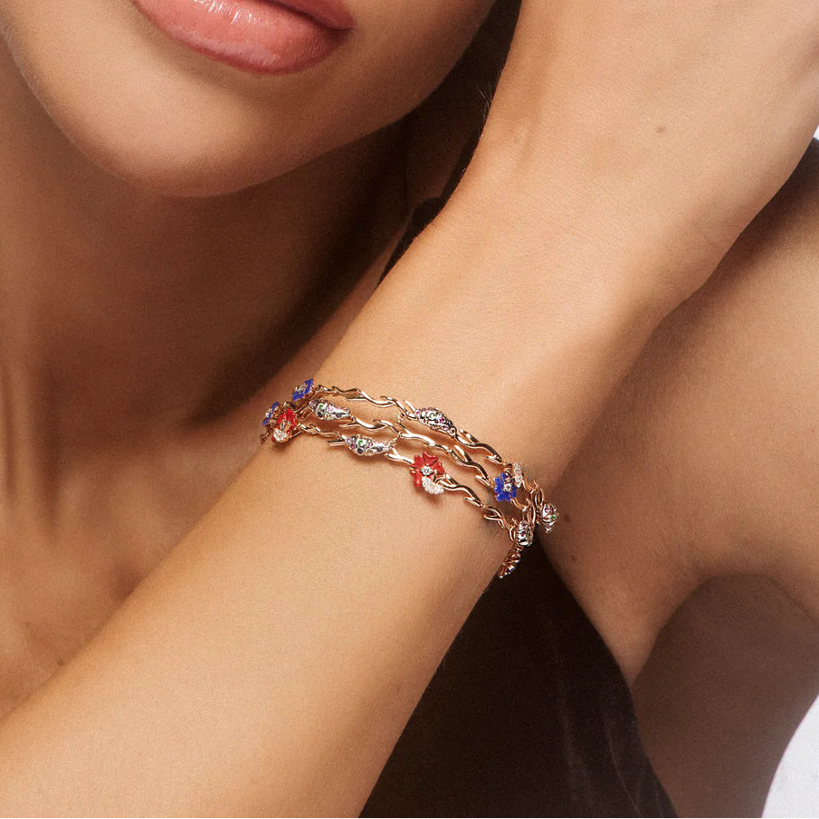 Close-up of a woman's wrist wearing a delicate bracelet with colorful stones.