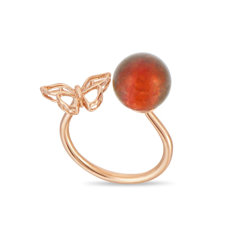 Rose gold ring with a butterfly design and amber-colored bead on a white background