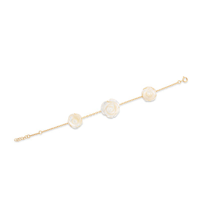 Gold bracelet with three pearl-like beads on a white background