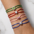 Five colorful bracelets on a wrist against a marble background