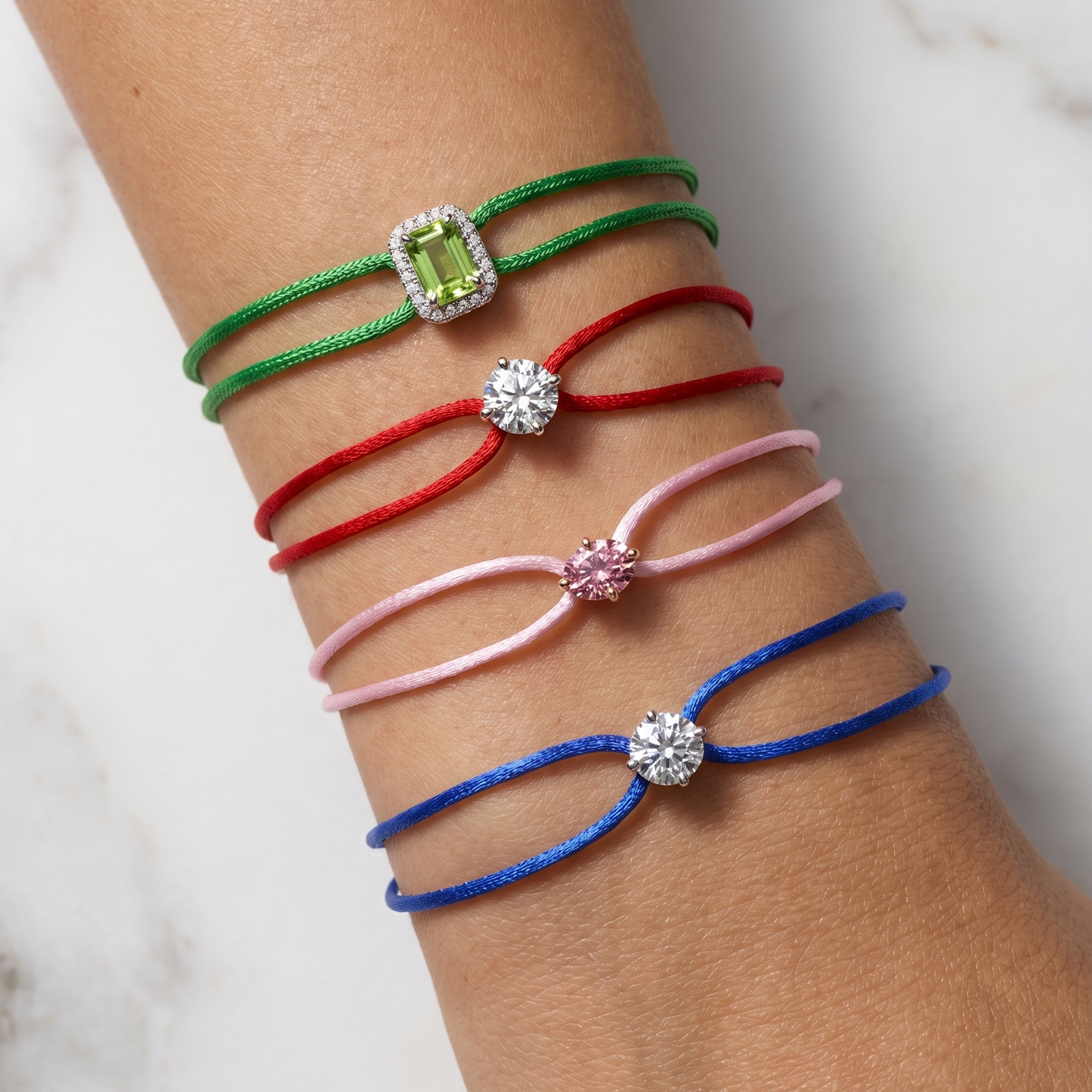 Five colorful bracelets on a wrist against a marble background